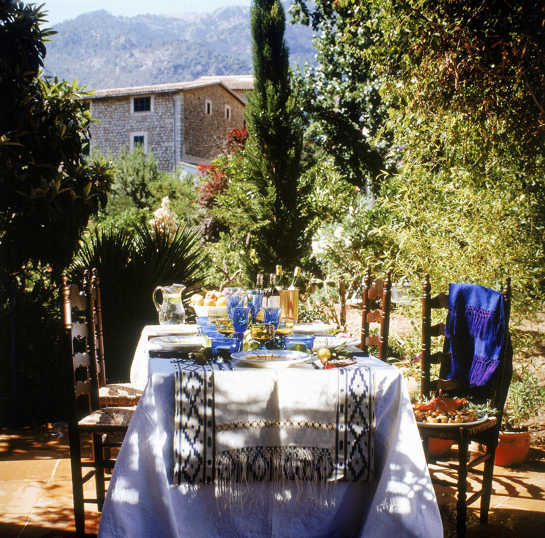 Für ein sommerliches Abendessen gedeckter Tisch auf einer Terrasse