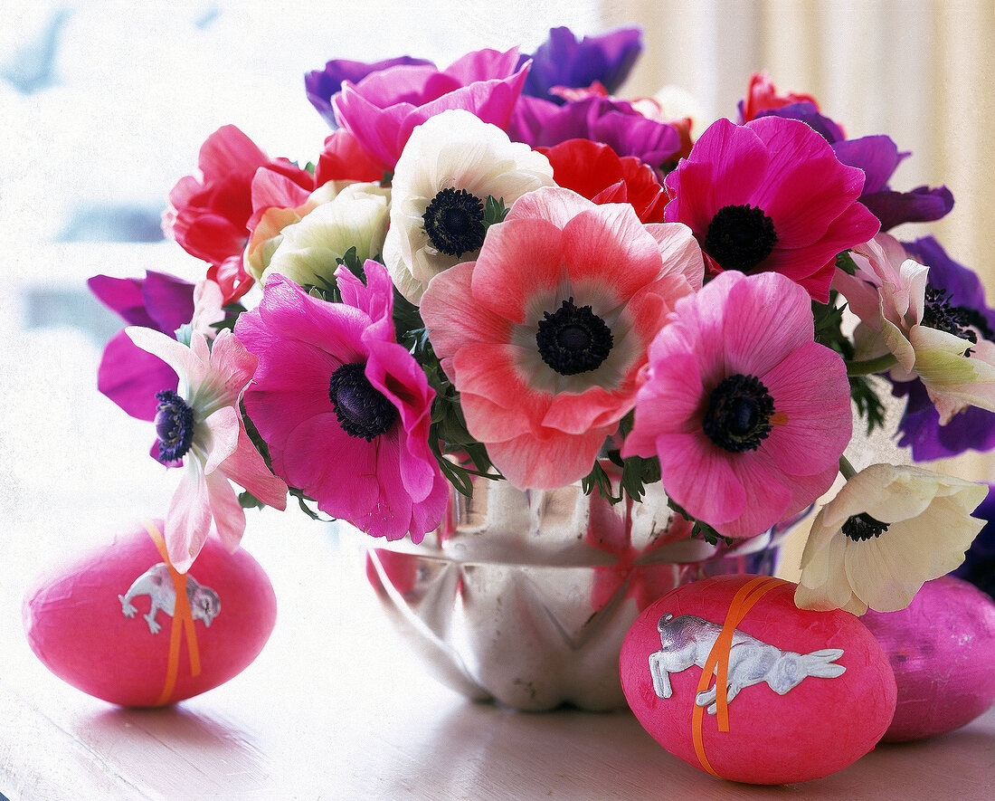 Anemones in a baking tin as a flower vase, next to them decorative eggs