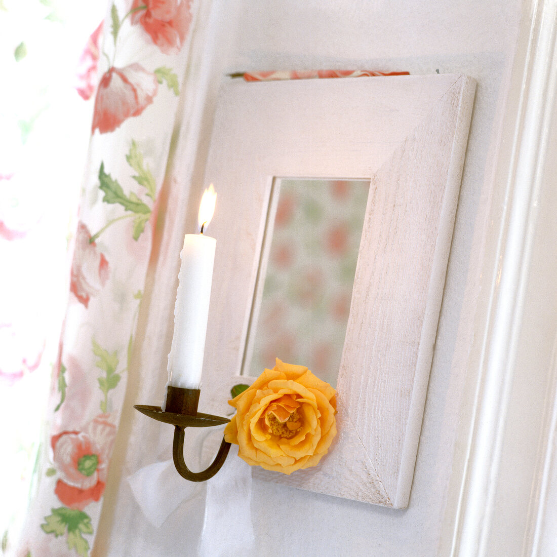 Spiegel im weißlasierten Holzrahmen mit Kerzenhalter und Blüte