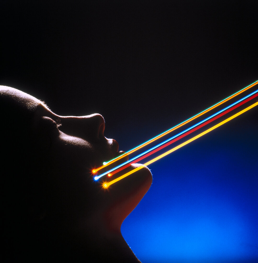 Close-up of woman's face with multi coloured laser beams
