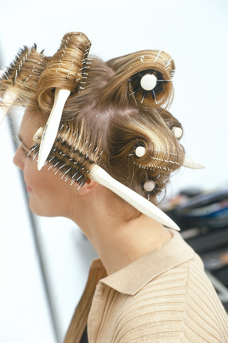 Side view of blonde woman with round brushes curled in her hair