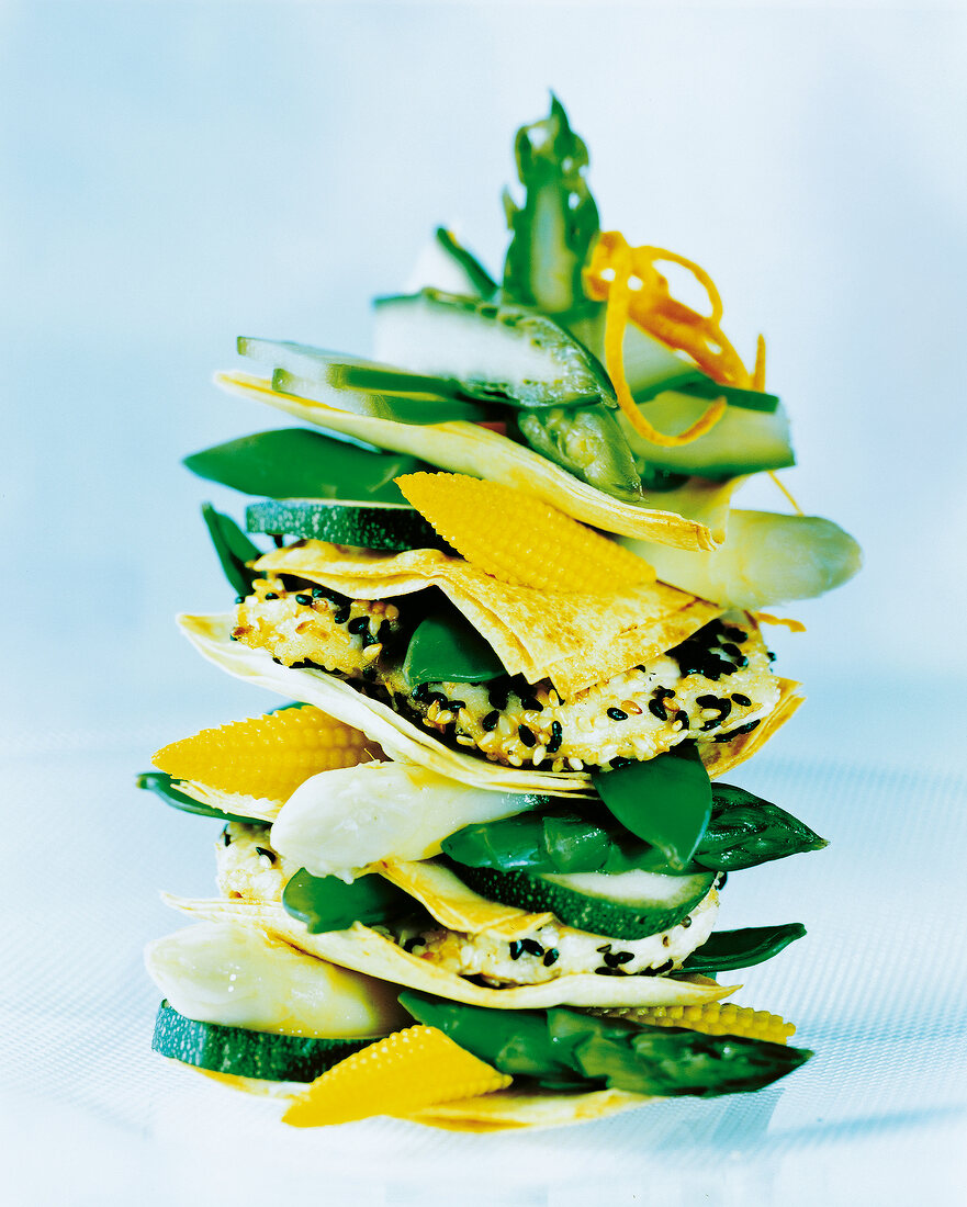 Stack of breaded tofu with sesame seeds and slices of zucchini