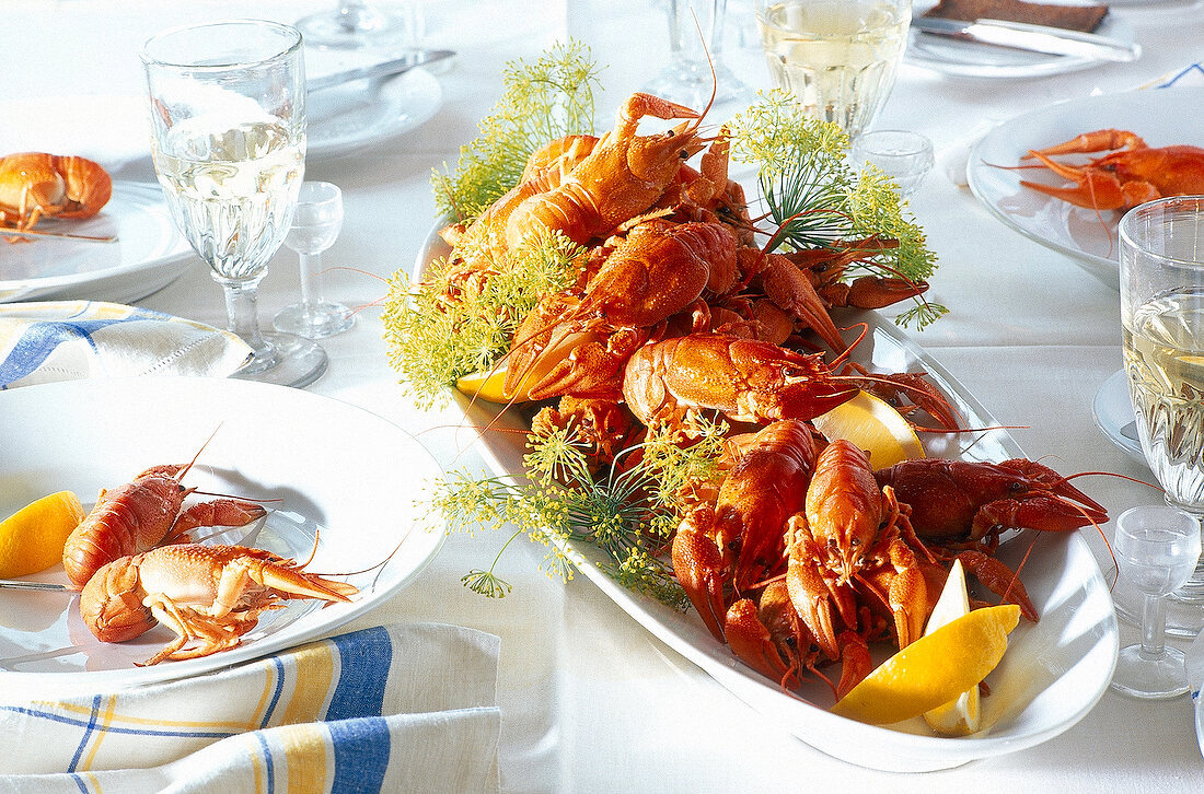 Table laid with crayfish and wine glasses