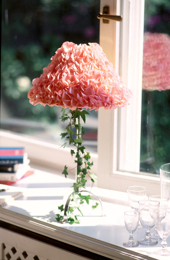 Table lamp decorated with pink rose petals and ivy