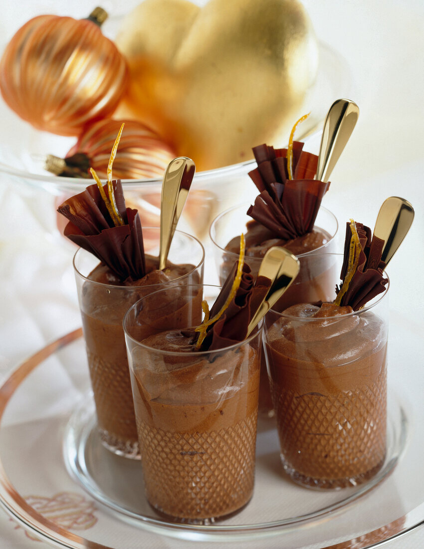 Glasses of chocolate mousse with chocolate flakes on plate