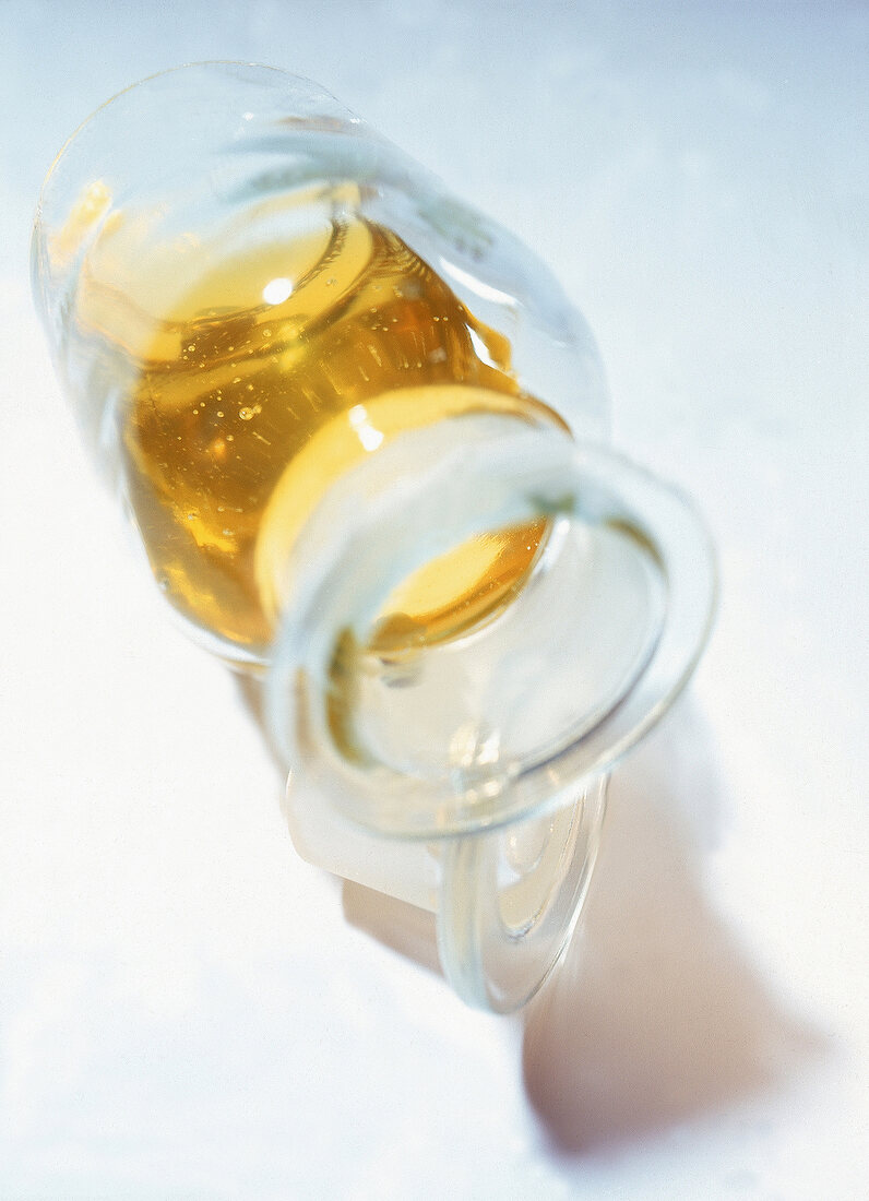 Weizenkeim-Rosenöl in einer liegenden Glasflasche, die geöffnet ist