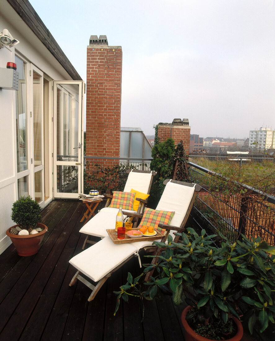 Dachterrasse mit Holzboden, Pflanzen u. Liegestühlen