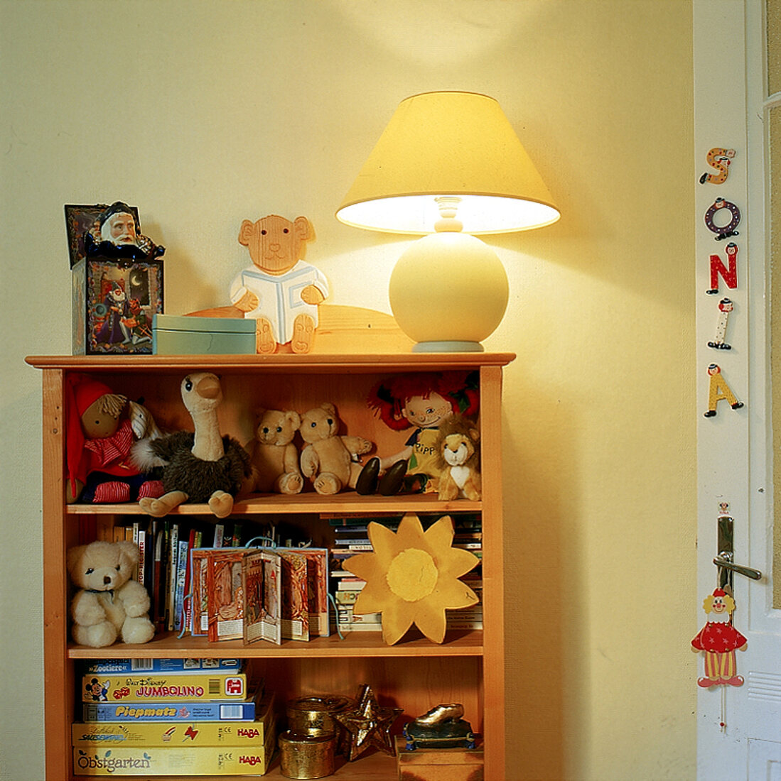 Regal aus massivem Holz mit Kuscheltieren, Büchern, Spielen und Lampe