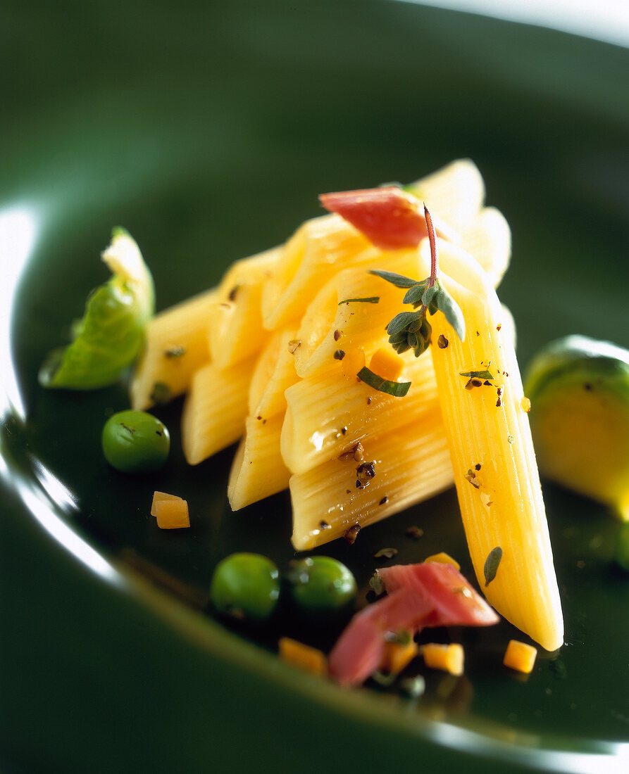 Close-up of penne with vegetables, ham and herb sauce