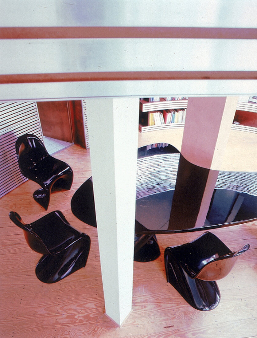 Asymmetrischer Tisch und gebogene Stühle aus glänzender Kohlefaser