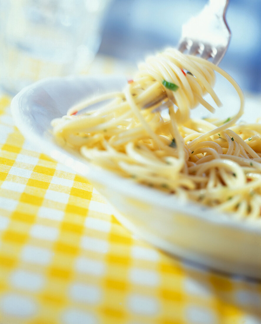 Ein Teller mit Spaghetti,werden auf eine Gabel gedreht, close up.