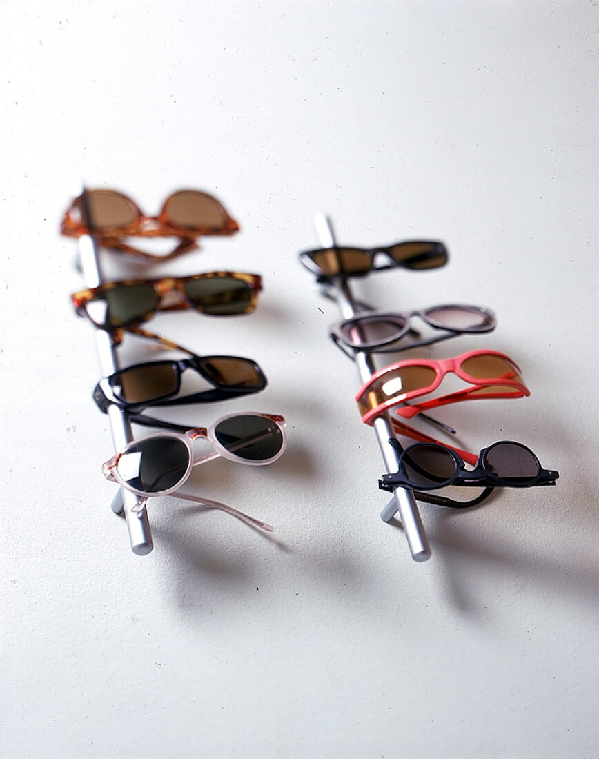 Diverse Damen Sonnenbrillen hängen an einer bzw.zwei Metallstangen.