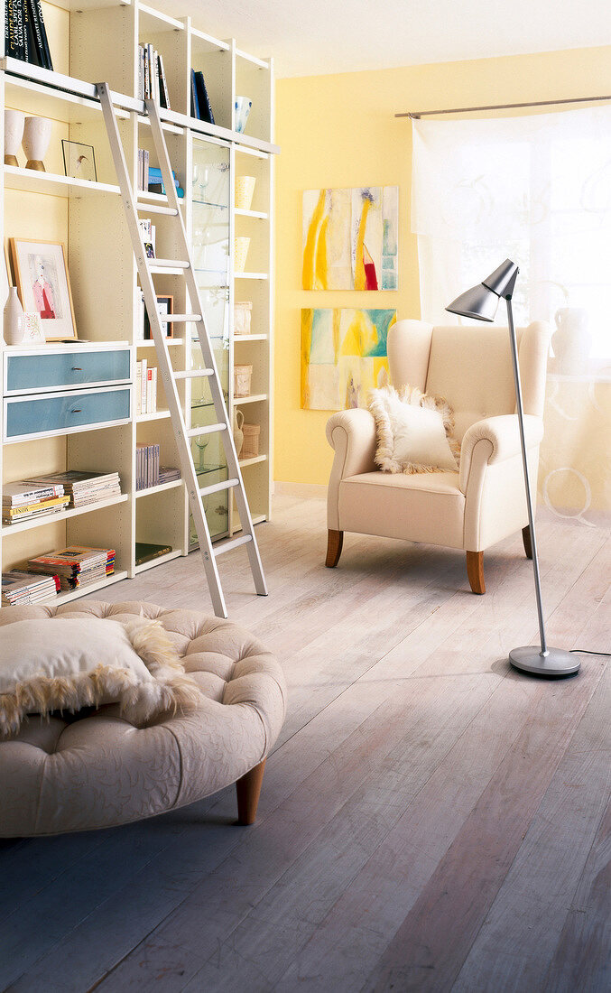 Display shelves, high back chair with pillow and ottoman in living room