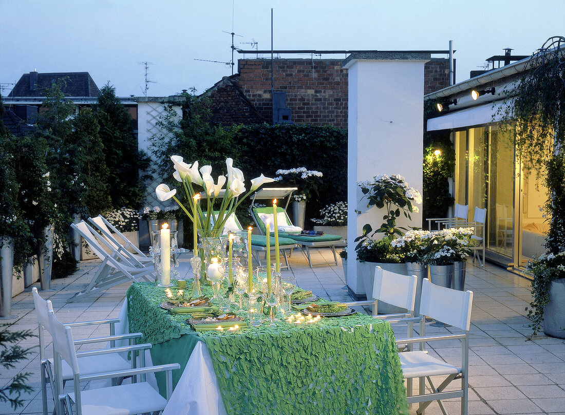 Festlich gedeckter Tisch auf einer Dachterrasse, Abendstimmung