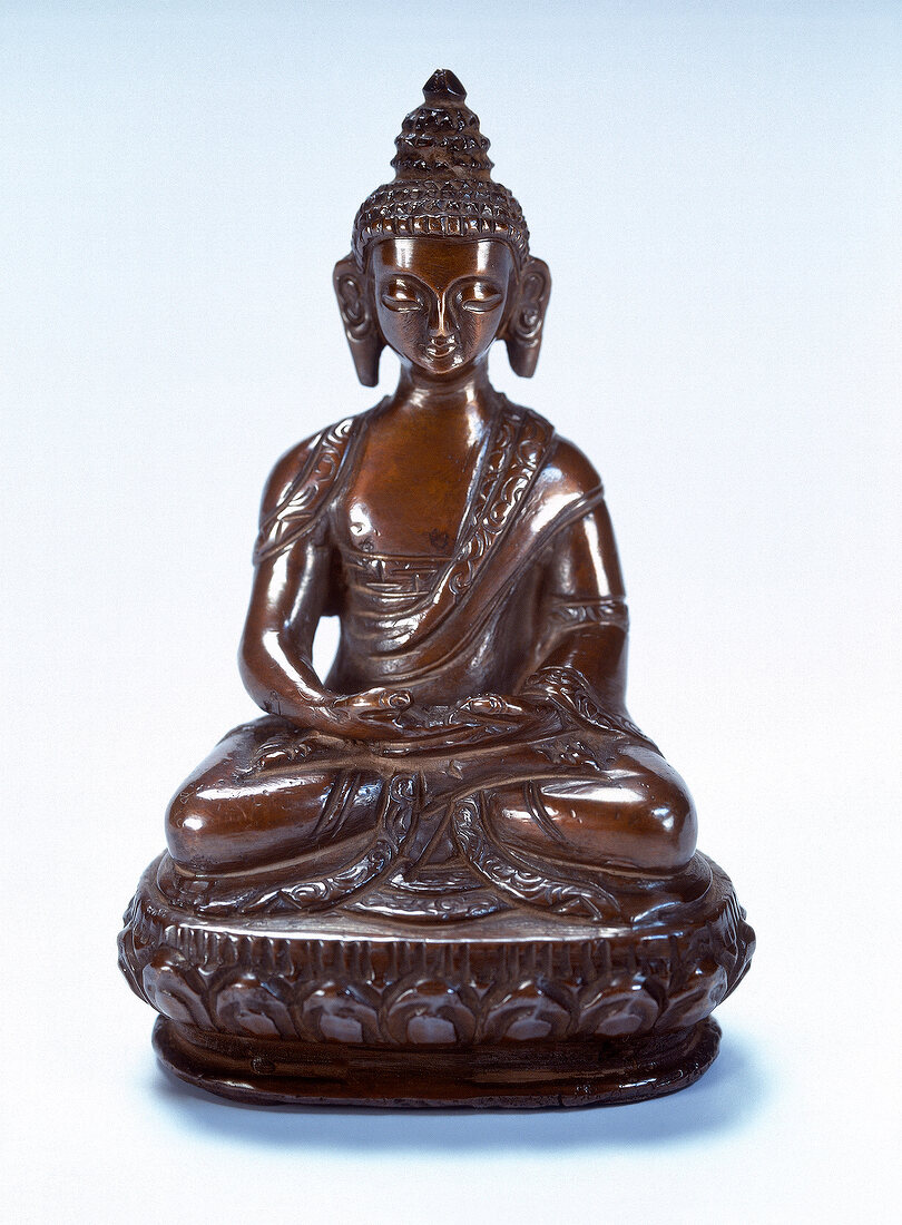 Bronze statue of Buddha against white background