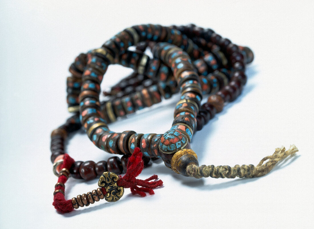 Close-up of wooden prayer beads on white background