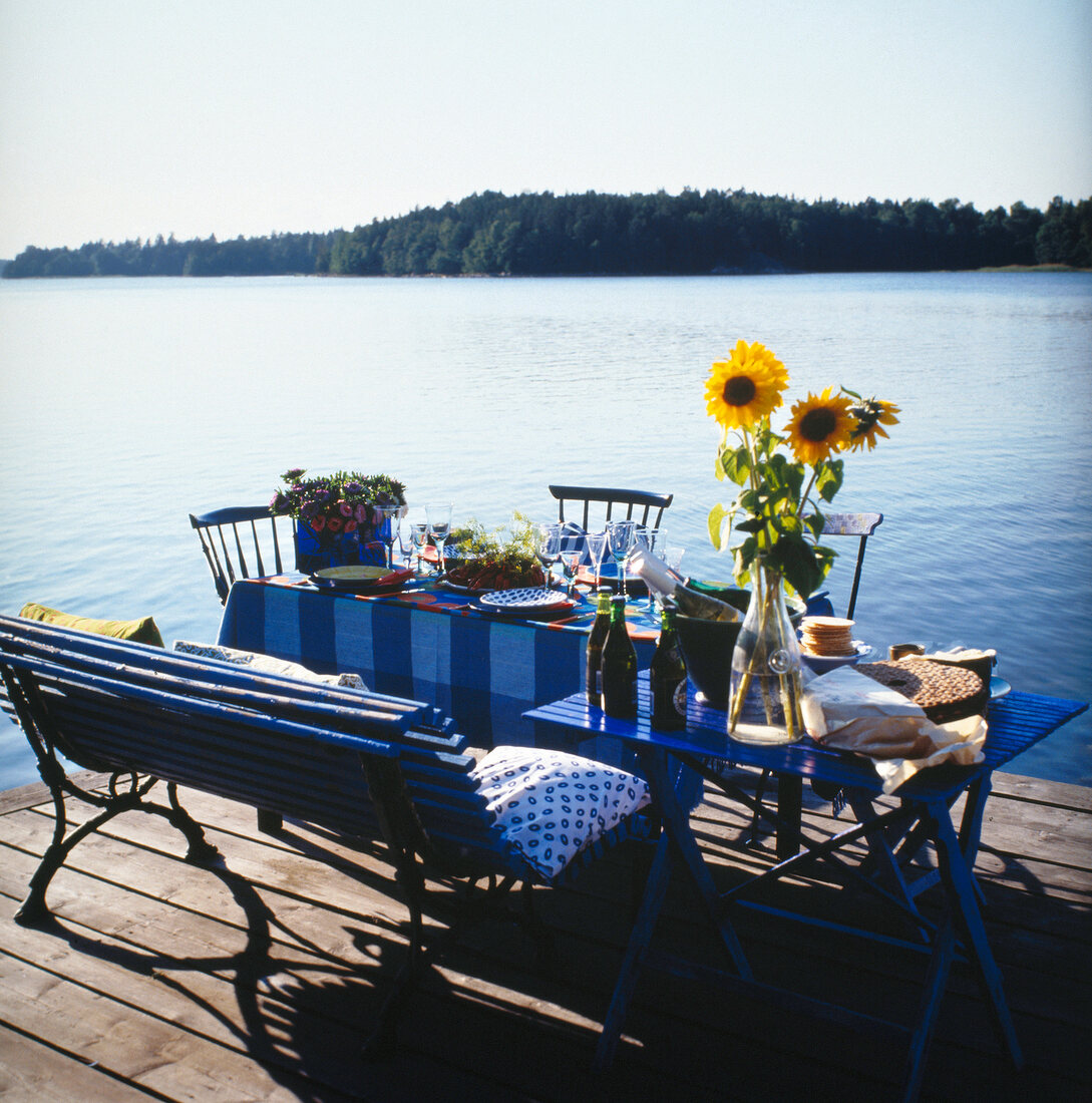 Blue table laid on jetty near lake