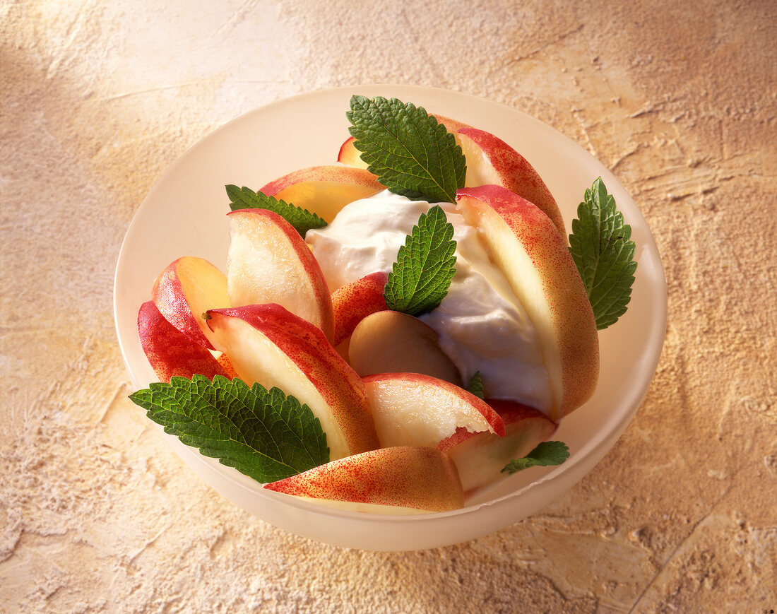 Cottage cheese, peach and mint leaves in bowl