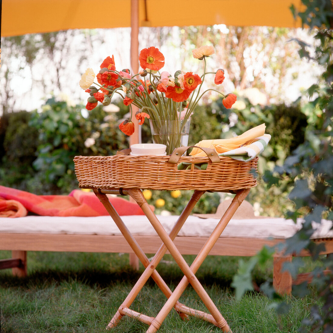 Wicker butler tray with flower vase on it