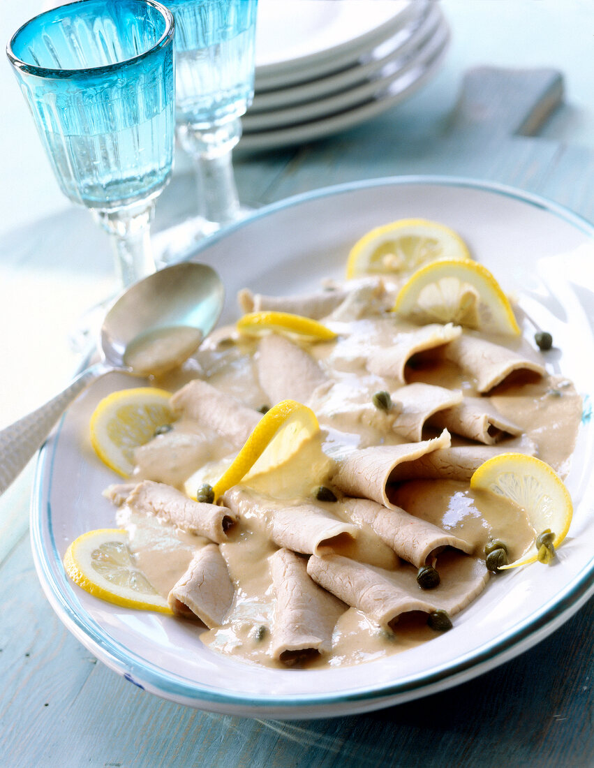 Vitello tonnato dish with sliced veal in flavoured tuna sauce on plate