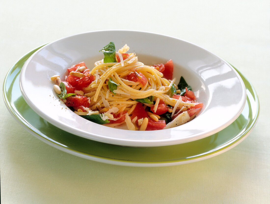 Spaghetti with arugula pesto and tomatoes on plate