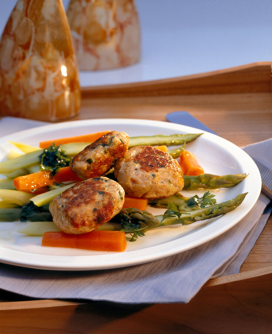 Poultry meatballs on asparagus salad on plate