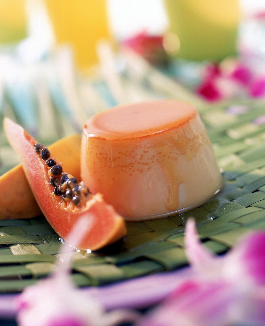 Papaya-Mango-Flan mit Papayaviertel dekoriert, Unschärfe