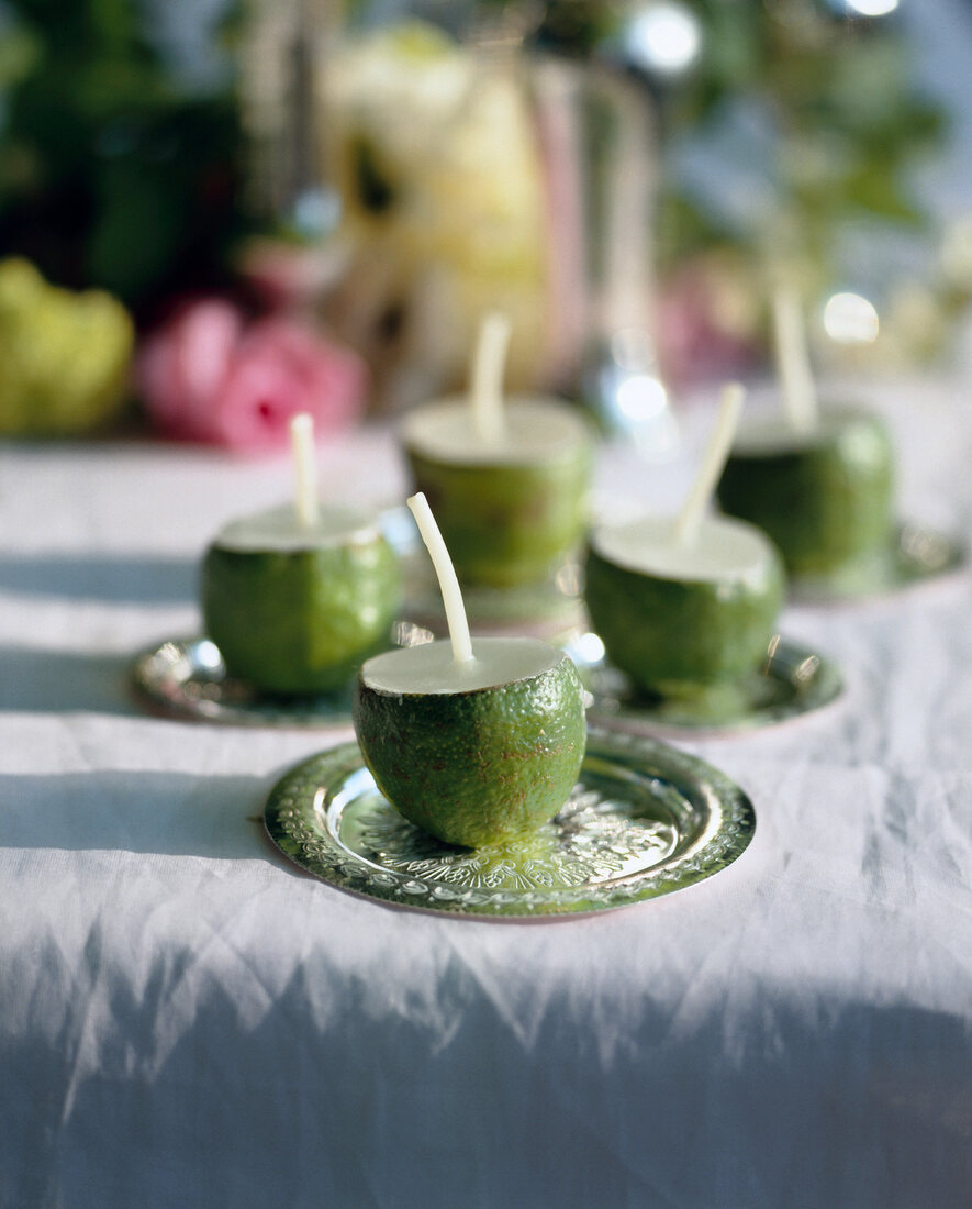 Limonenschalen mit Docht und Wachs gefüllt dienen als Tischlichter