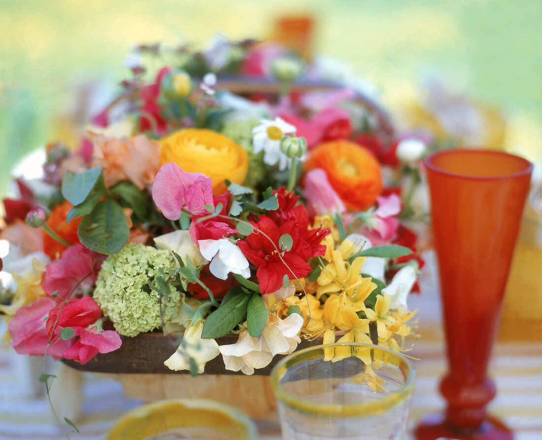 Arrangement aus Sommerblumen in einem Korb dient als Tischdekoration