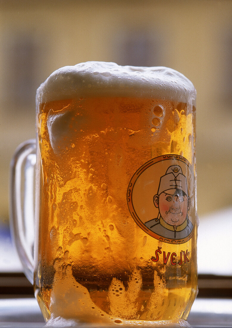 Bierglas mit dem Soldaten Svejk und überlaufendem tchechischem Bier