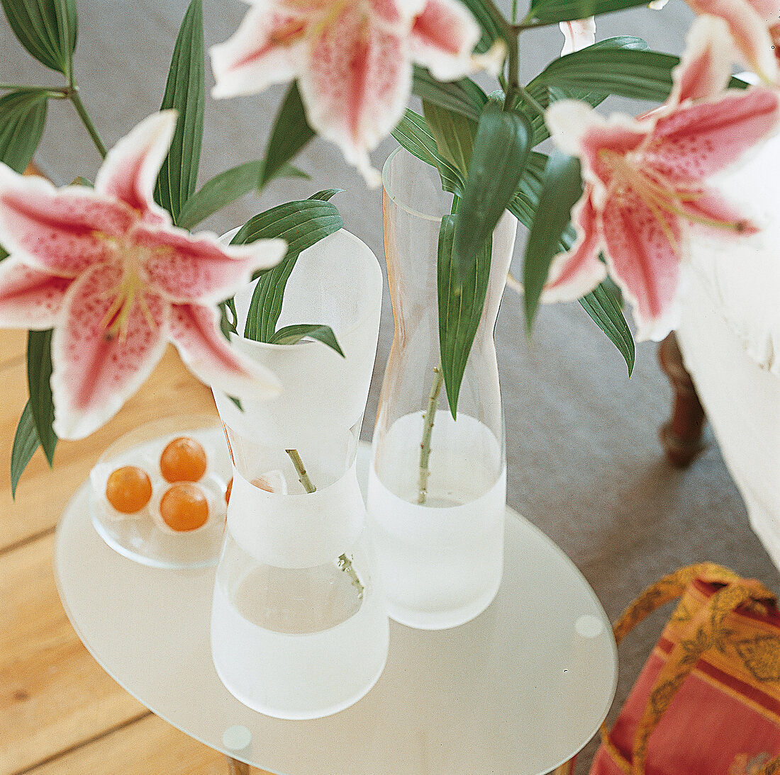 Zwei Vasen mit Streifen aus Klar-und Milchglas mit einzelnen Lilien