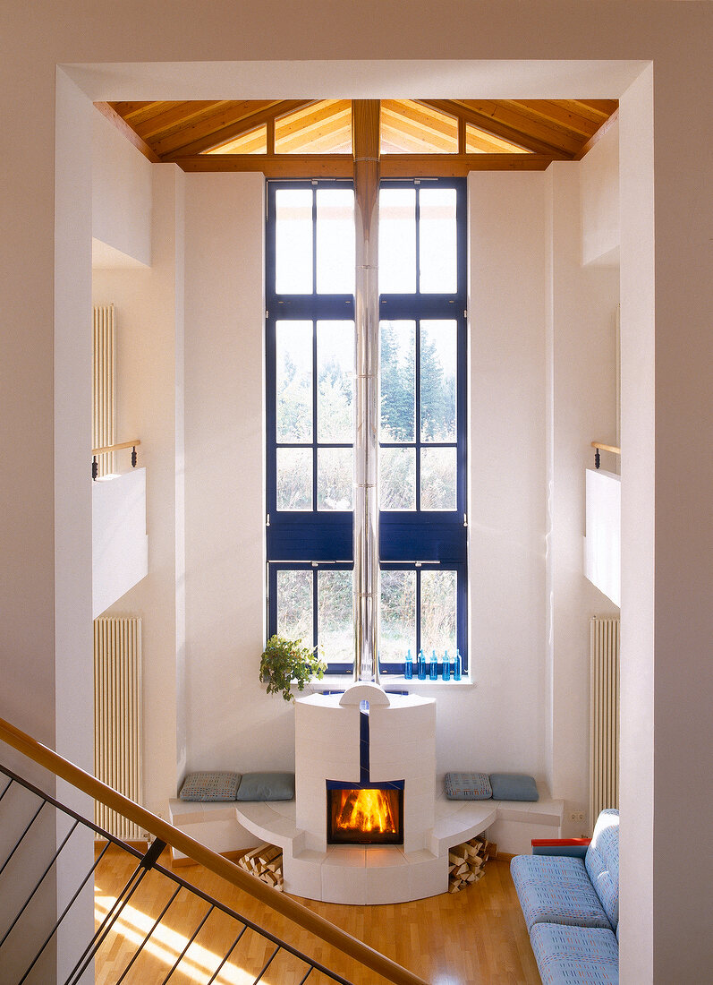 Wohnraum (Halle) mit Kamin mit Ofen- bänken und umlaufender Galerie