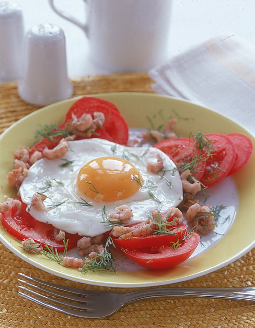 Spiegeleier mit Krabben und Dill auf Tomaten