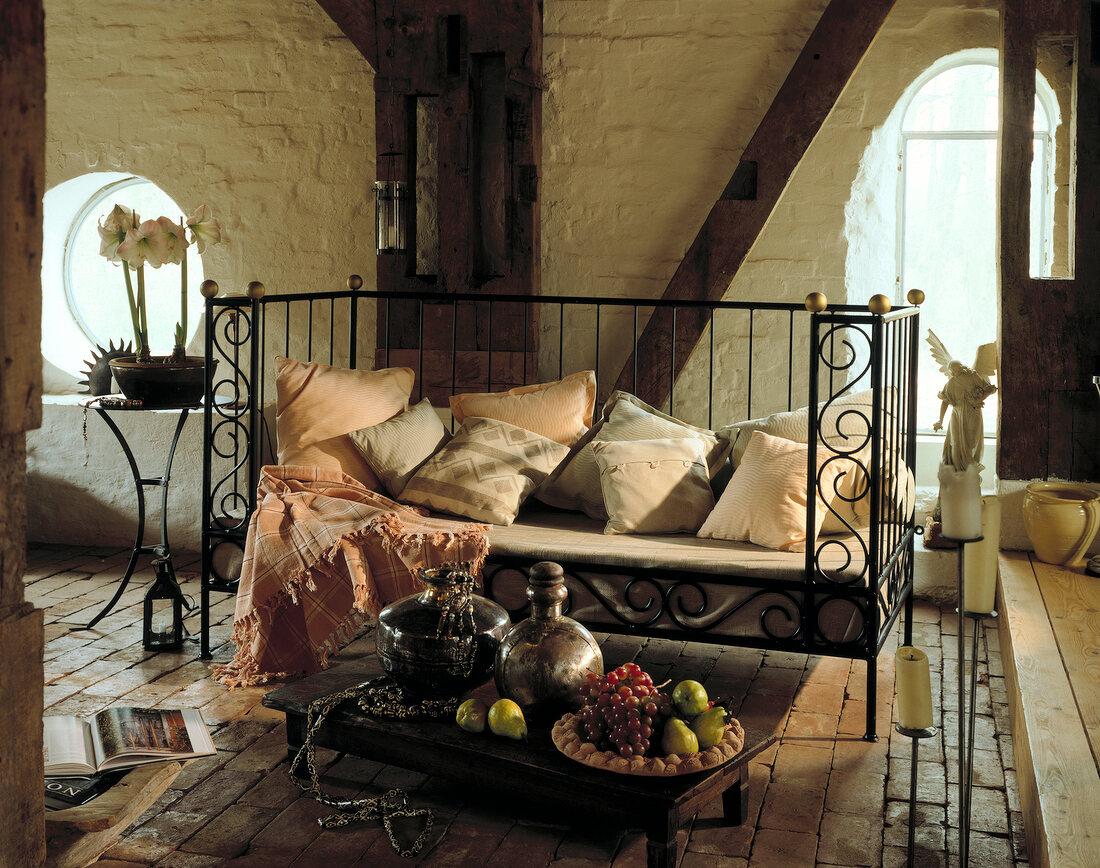Squiggly iron bed with pillows in rustic room