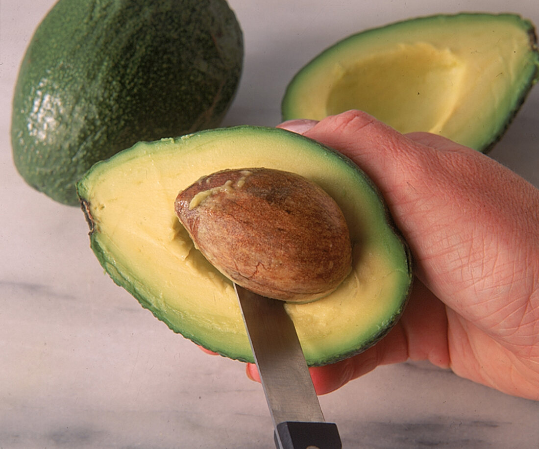 Avocadokern mit einem spitzen Messer herauslösen