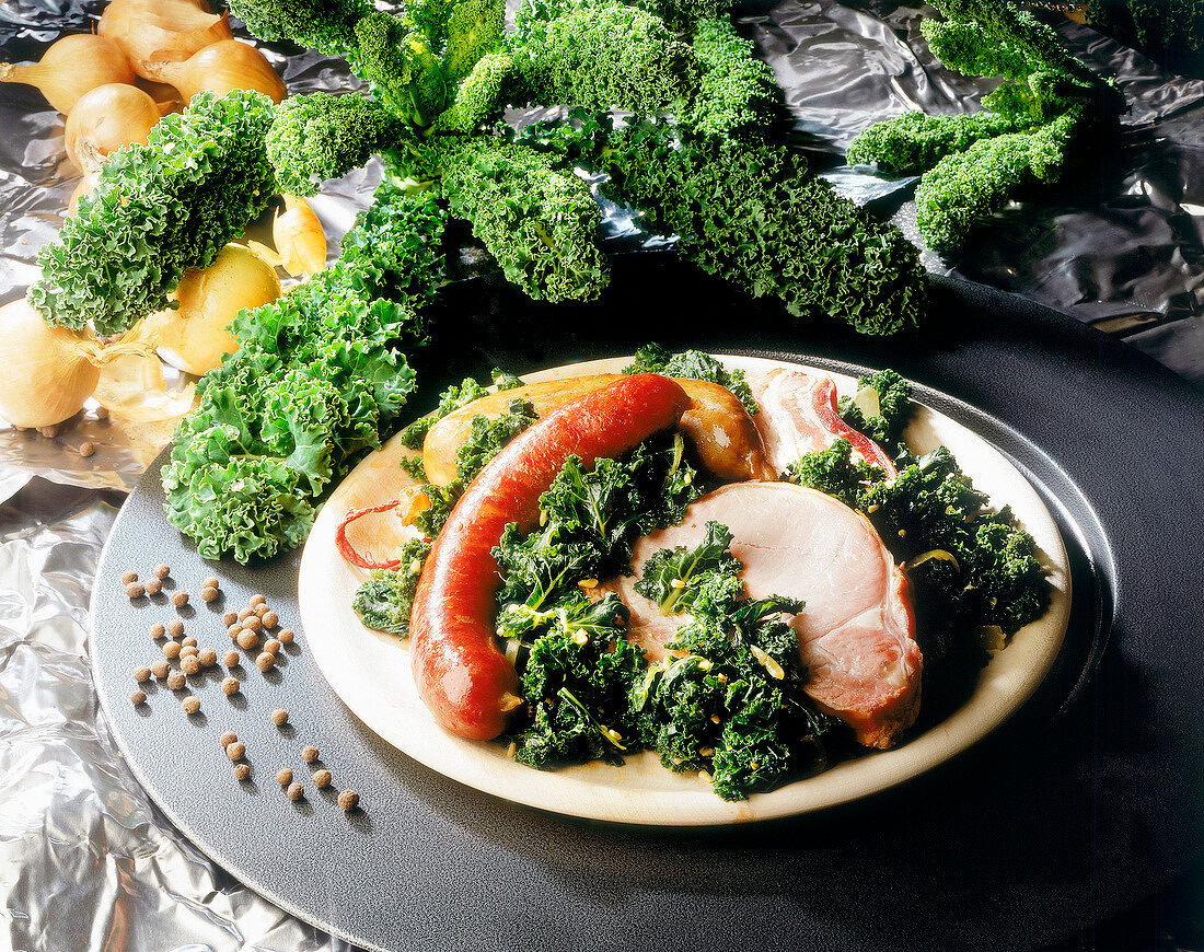 Kale, bacon and pinkel on plate with raw kale in background