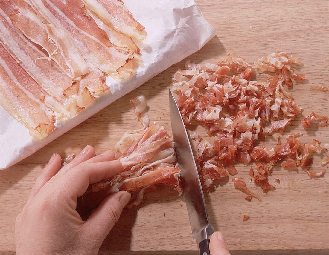 Schinkenspeckscheiben (Pancetta) in Würfel schneiden