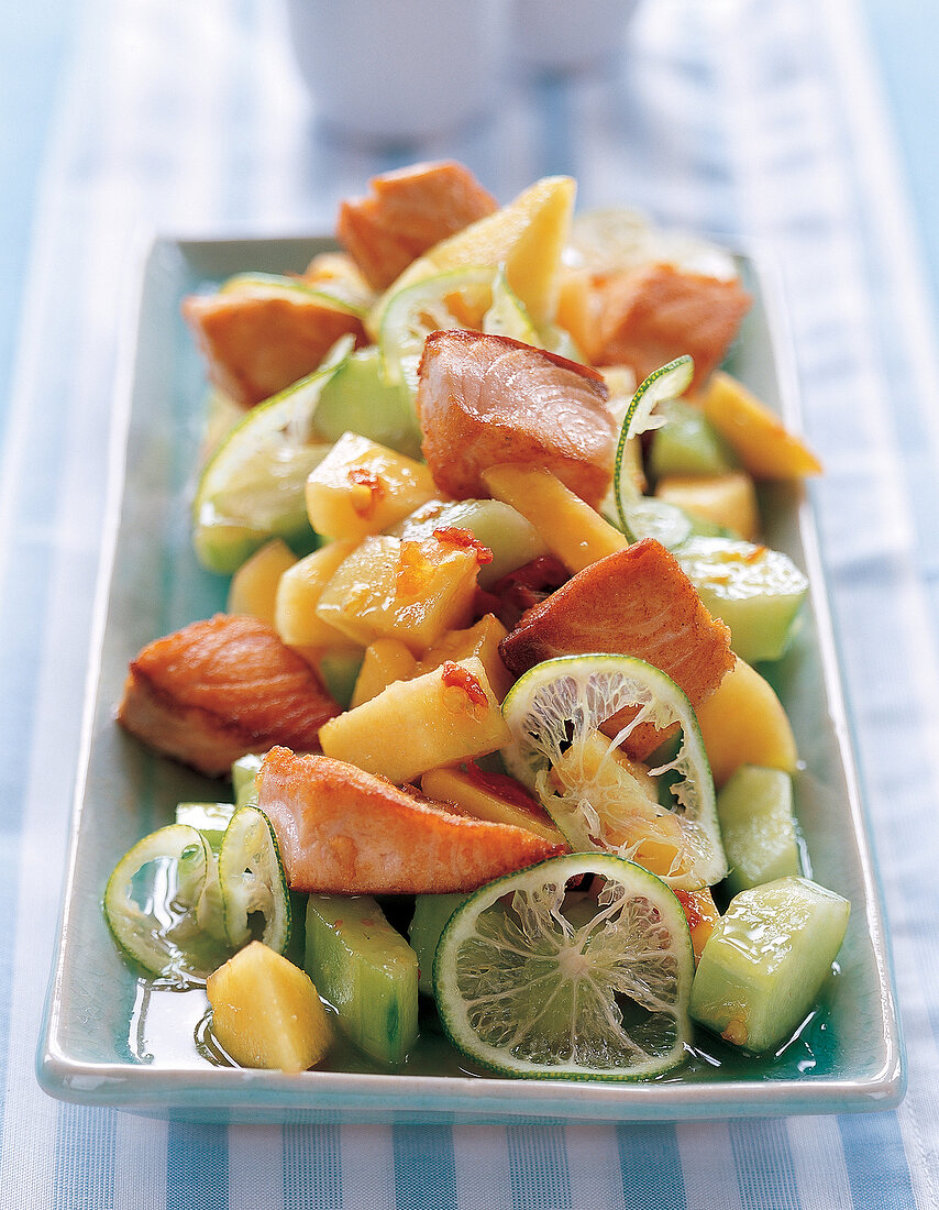 Melonensalat mit angebratenen Lachsstücken,Gurke,Limetten