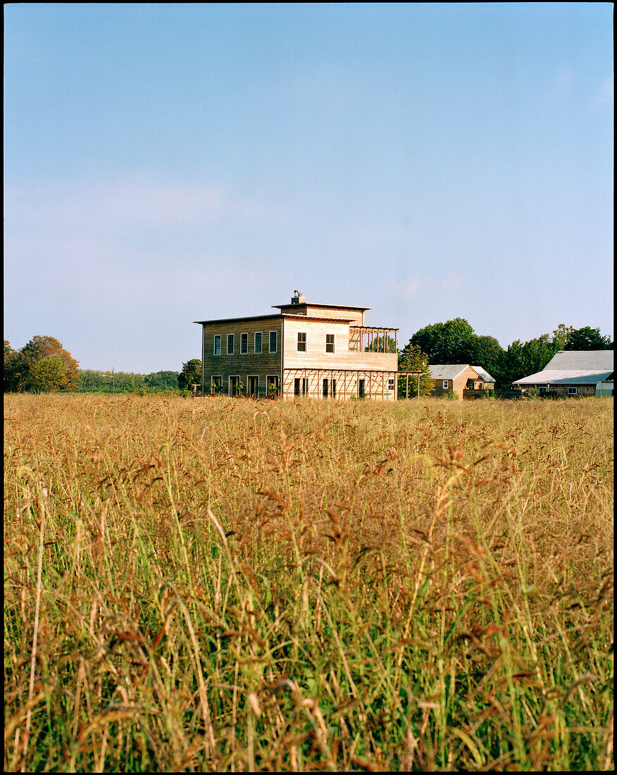 Exterior of American wooden house in the middle of wild meadow