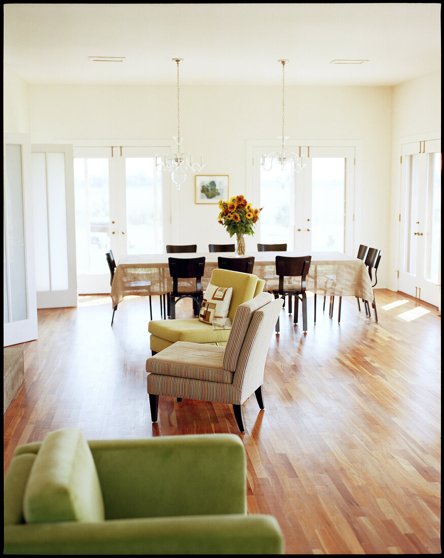 View of living room with large dinning table and chairs on wooden floor