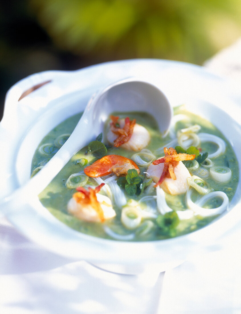 Close-up of peas and pear soup with rice noodles and scallops in bowl