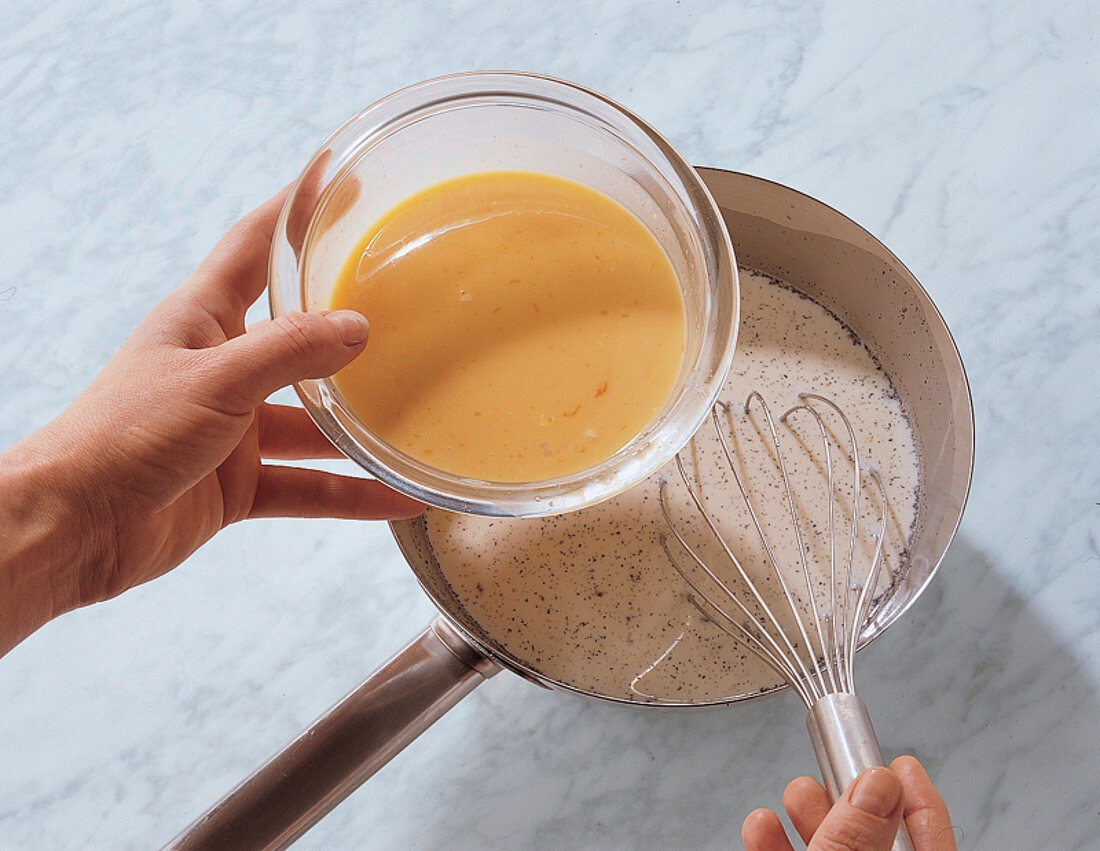 Eigelbsahne wird in Vanillemilch eingerührt