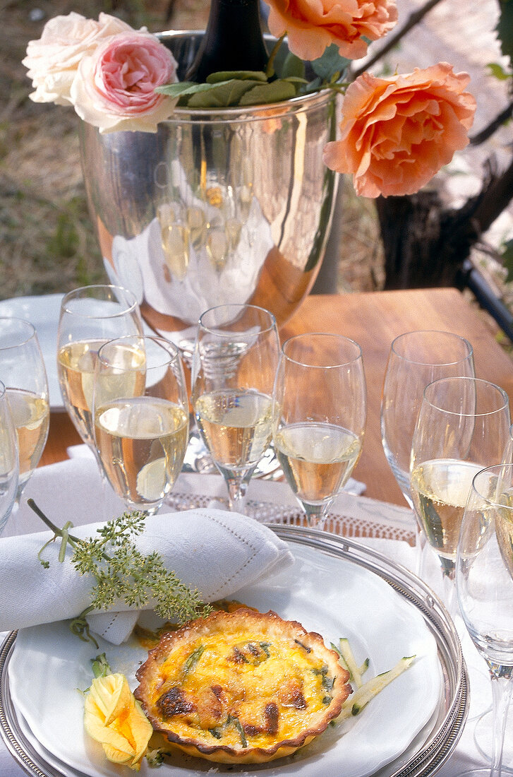 Zucchini quiche next to glasses filled with champagne on table