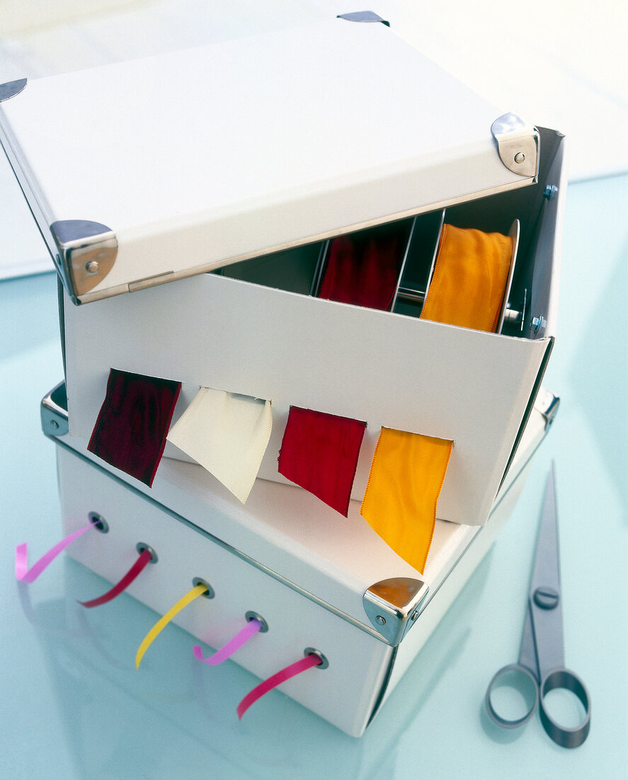 White boxes with ribbon dispenser and multi-coloured ribbons