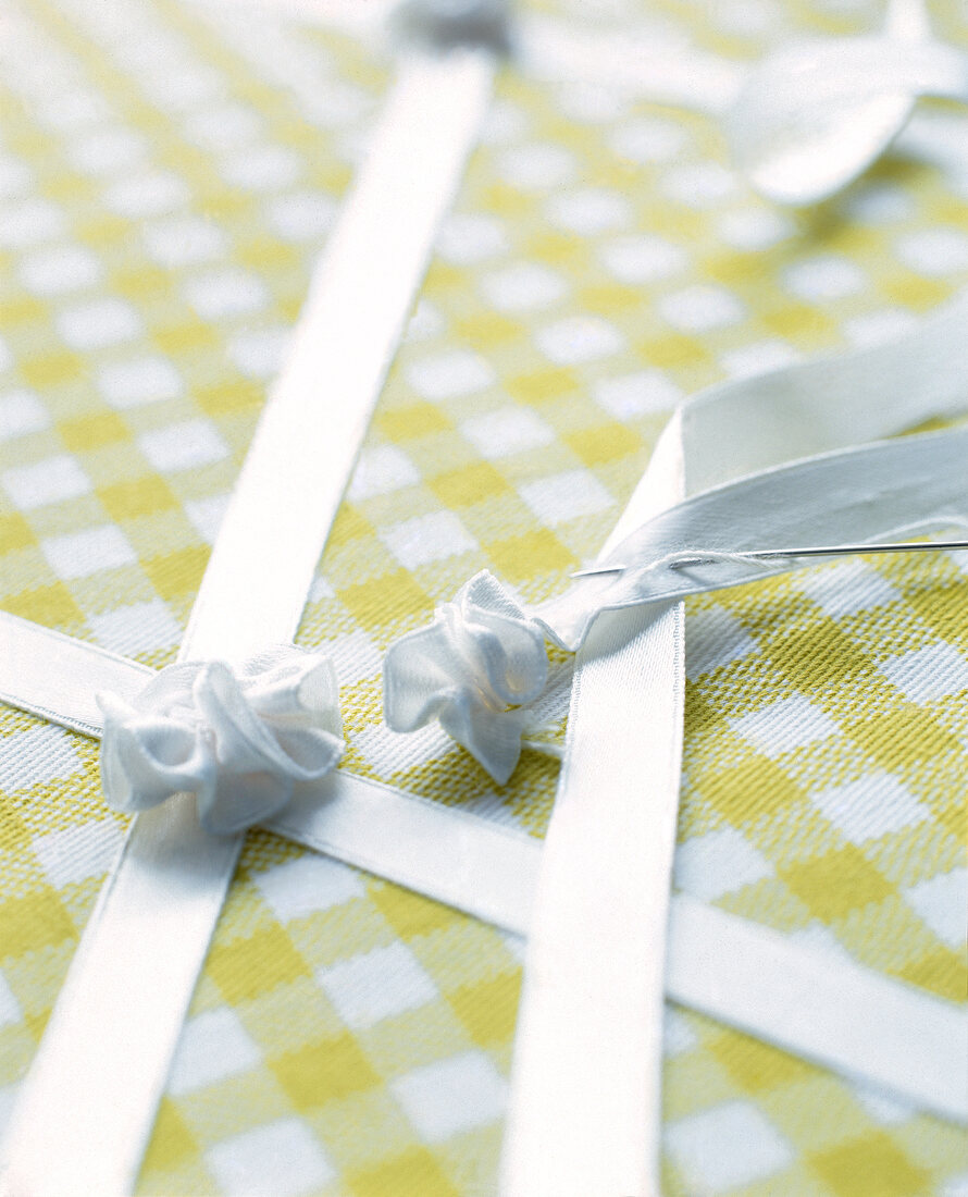 Close-up of pinboard with green plaid fabric in vichy style and sewn ribbon