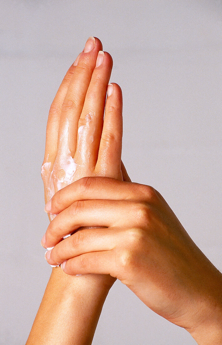 Close-up of hands applying cream