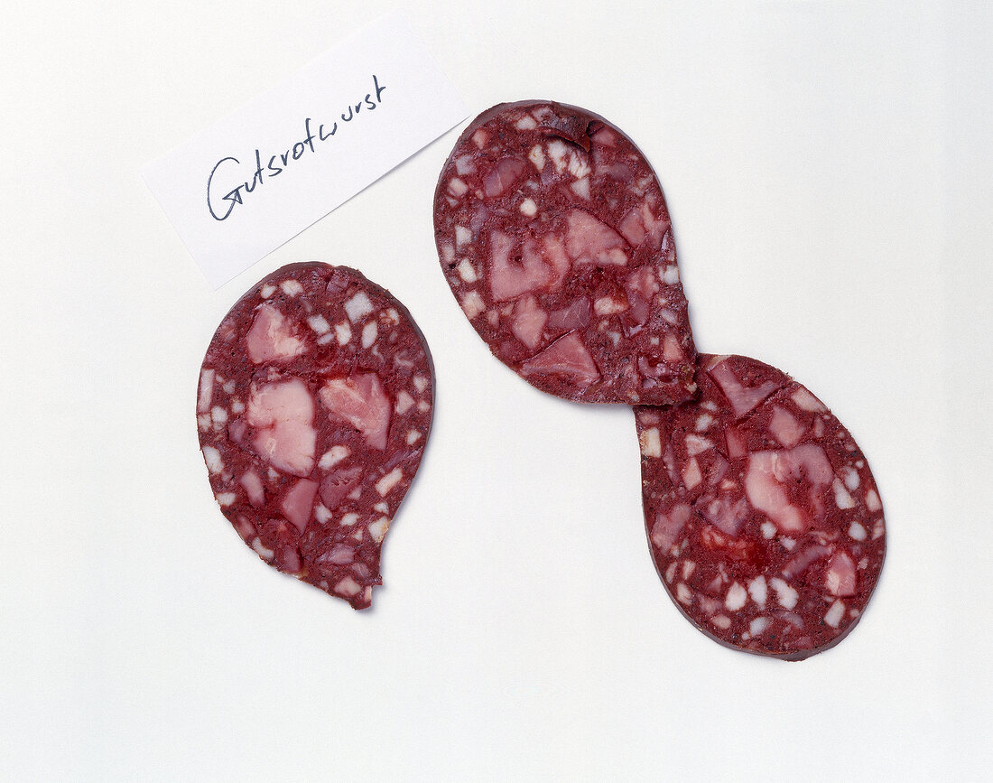 Slices of gutsrotwurst sausages on white background