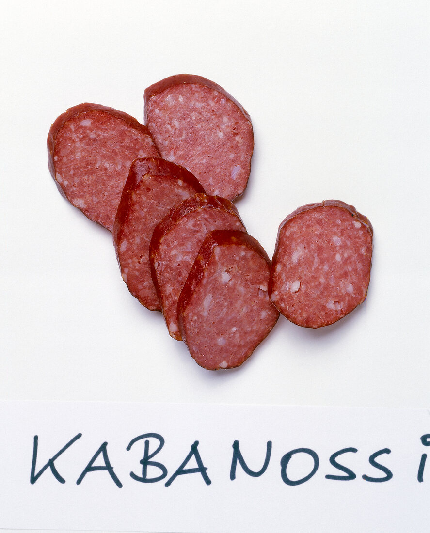 Slices of cabanossi sausages on white background