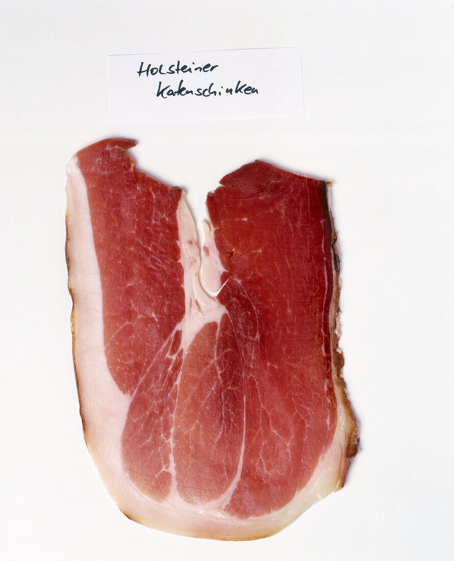 Slice of Holsteiner ham on white background