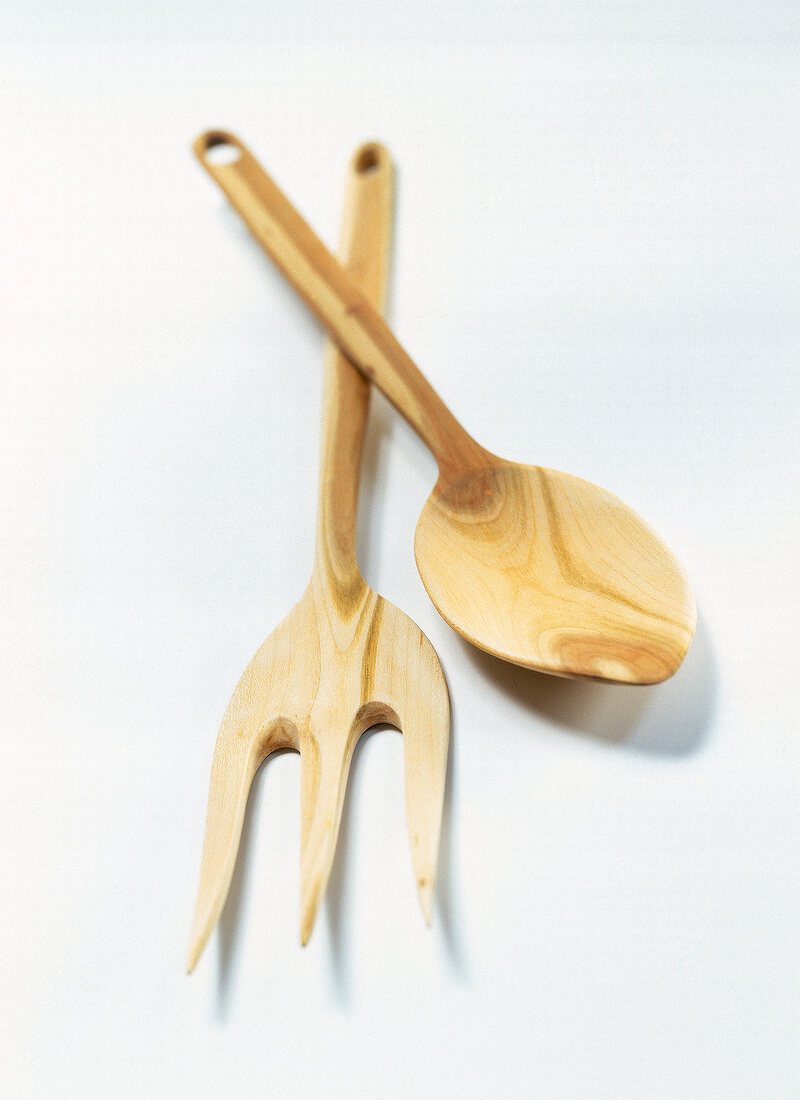 Close-up of wooden salad server against white background